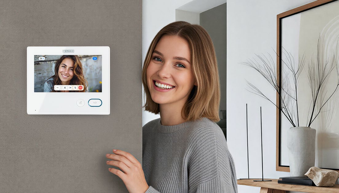 Monitor FERMAX IRIS blanco instalado en una vivienda, mostrando una videollamada